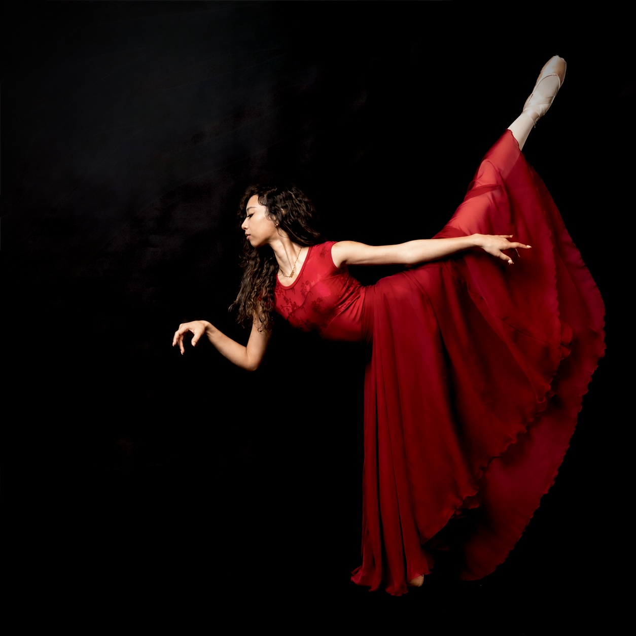 Inaya Malik en pointe in flowing red dress — arabesque